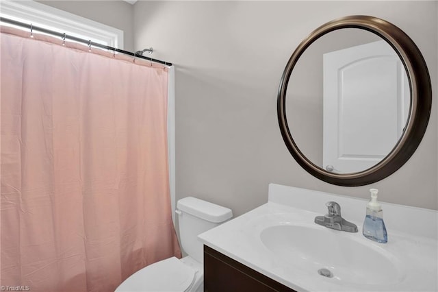 bathroom with a shower with shower curtain, vanity, and toilet