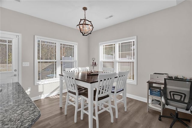 dining room with plenty of natural light, an inviting chandelier, and hardwood / wood-style flooring