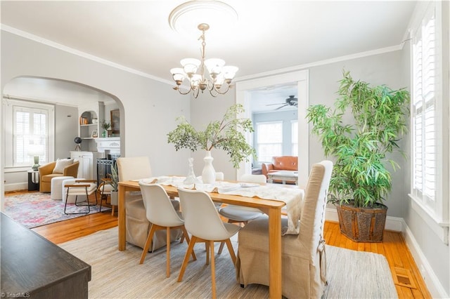 dining area featuring crown molding, plenty of natural light, a chandelier, and light hardwood / wood-style floors