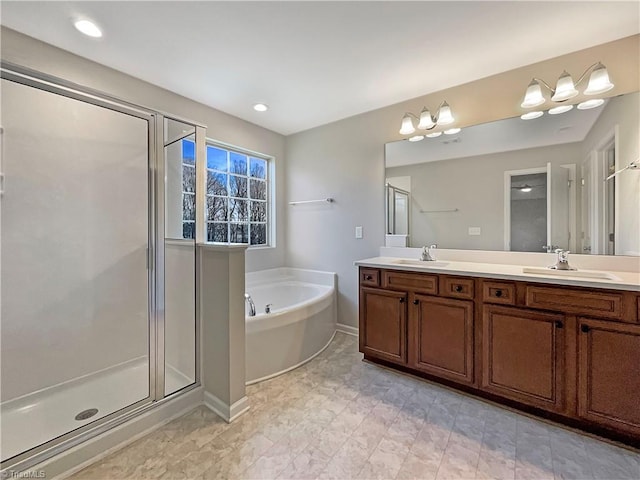 bathroom with a garden tub, a sink, a shower stall, and double vanity