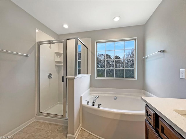 bathroom with vanity, a shower stall, a bath, and baseboards