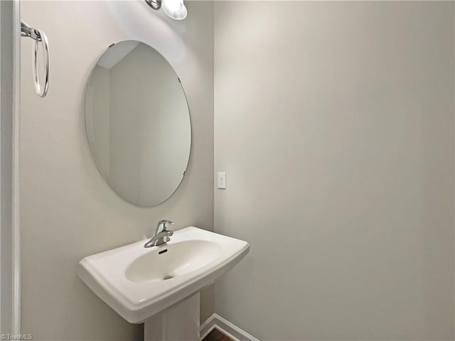 bathroom featuring baseboards and a sink