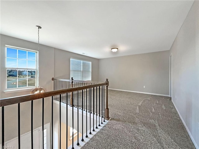 hall featuring plenty of natural light, carpet, an upstairs landing, and baseboards