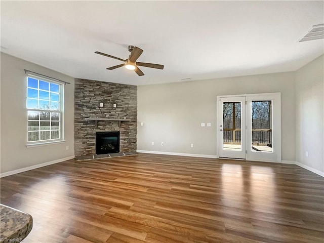 unfurnished living room with a ceiling fan, a fireplace, baseboards, and wood finished floors