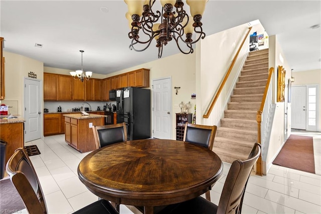 dining area featuring a notable chandelier and light tile patterned flooring