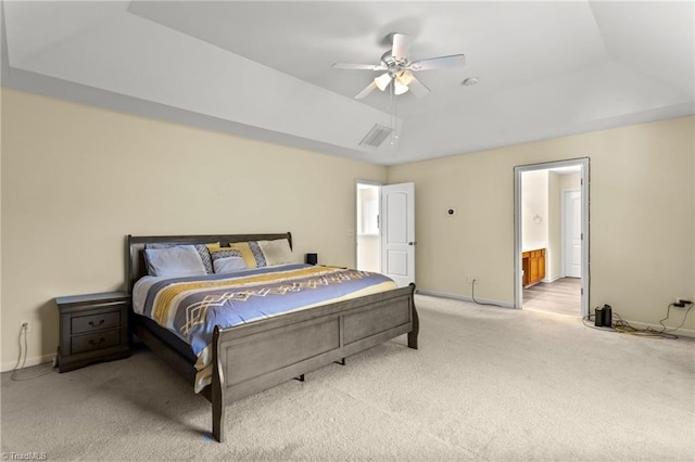 bedroom with light carpet, ensuite bathroom, ceiling fan, a tray ceiling, and lofted ceiling