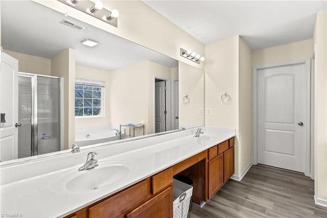 bathroom featuring wood-type flooring, vanity, and shower with separate bathtub