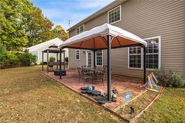 back of property featuring a lawn, a patio area, and a gazebo