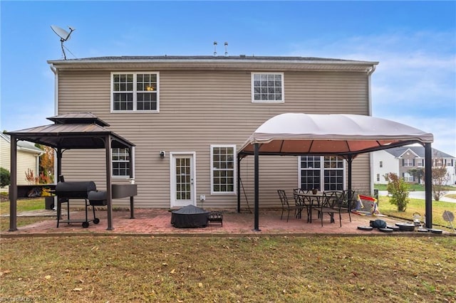 rear view of property featuring a patio, a yard, and a gazebo