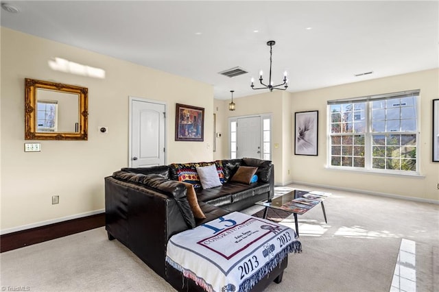 living room with light colored carpet and a notable chandelier