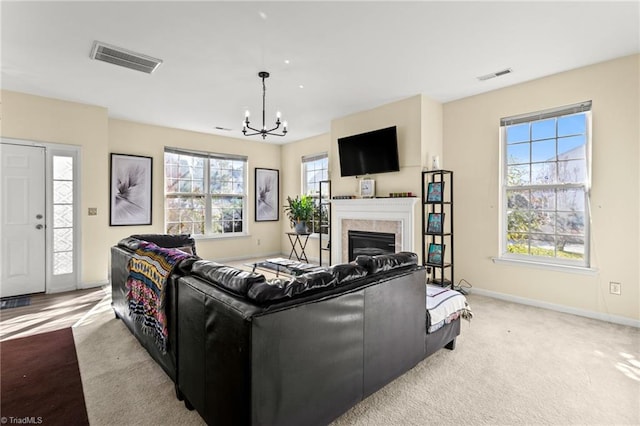 carpeted living room featuring a notable chandelier