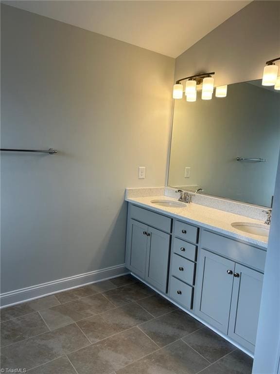 bathroom with tile patterned floors, vanity, and vaulted ceiling