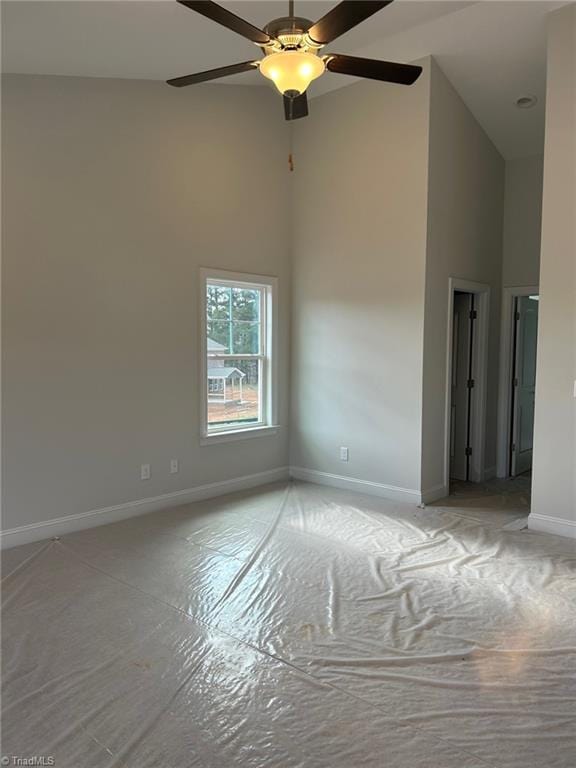 empty room featuring ceiling fan and high vaulted ceiling