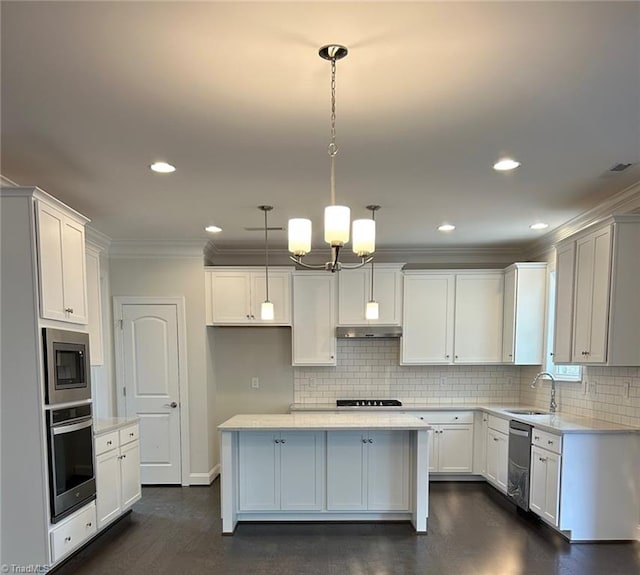 kitchen with sink, hanging light fixtures, white cabinets, a kitchen island, and appliances with stainless steel finishes