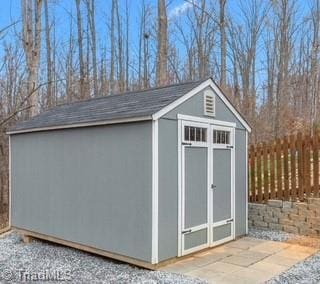 view of shed featuring fence