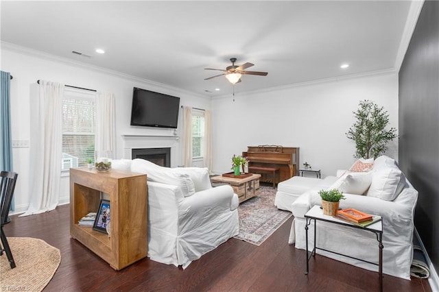 living room with ceiling fan, dark wood-style floors, a fireplace, and ornamental molding