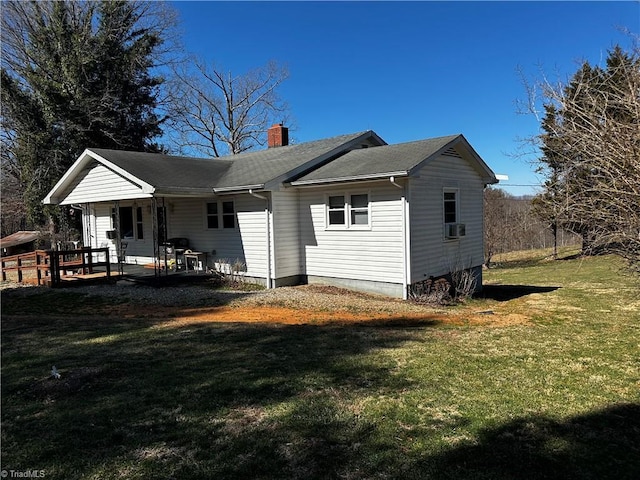 back of property featuring a porch, a lawn, and a chimney