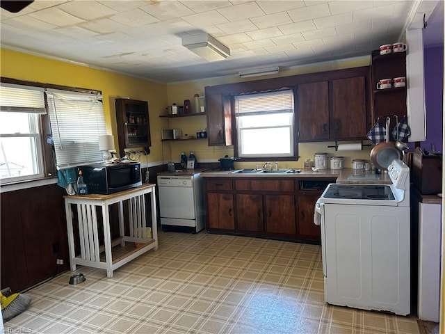 kitchen featuring white appliances, dark brown cabinets, light floors, open shelves, and a sink