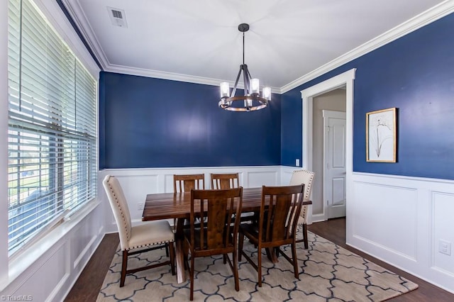 dining room featuring an inviting chandelier, crown molding, and wood finished floors