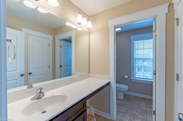 bathroom featuring vanity, toilet, and baseboards