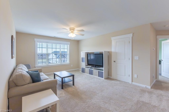 living room featuring light carpet, ceiling fan, and baseboards