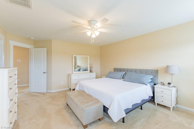 bedroom featuring visible vents, light carpet, and baseboards