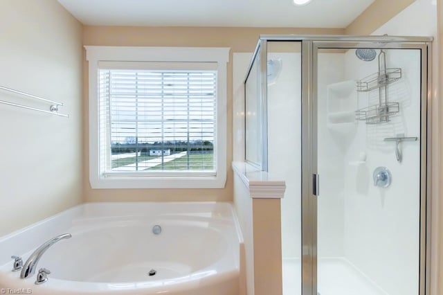 full bathroom featuring a stall shower and a garden tub