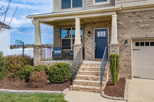 view of exterior entry with covered porch and brick siding