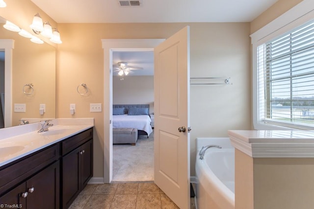 ensuite bathroom with a garden tub, connected bathroom, a sink, tile patterned floors, and double vanity