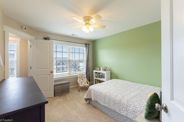 bedroom featuring light carpet, visible vents, and a ceiling fan