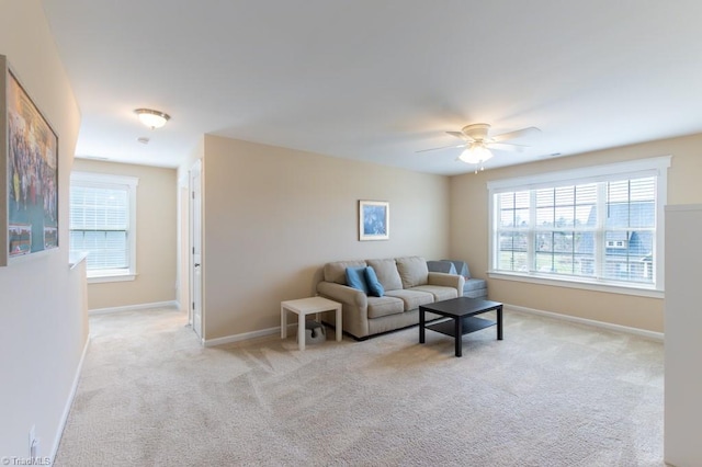 carpeted living room with ceiling fan and baseboards