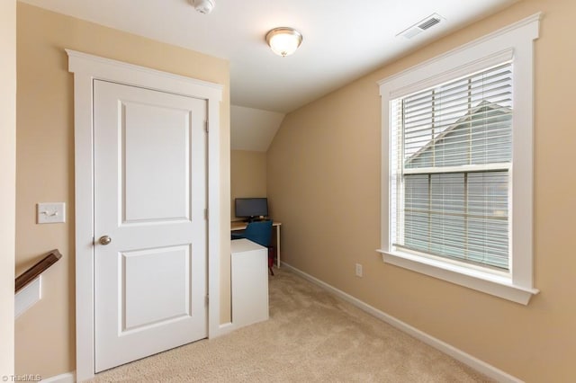 unfurnished bedroom featuring vaulted ceiling, baseboards, visible vents, and light colored carpet