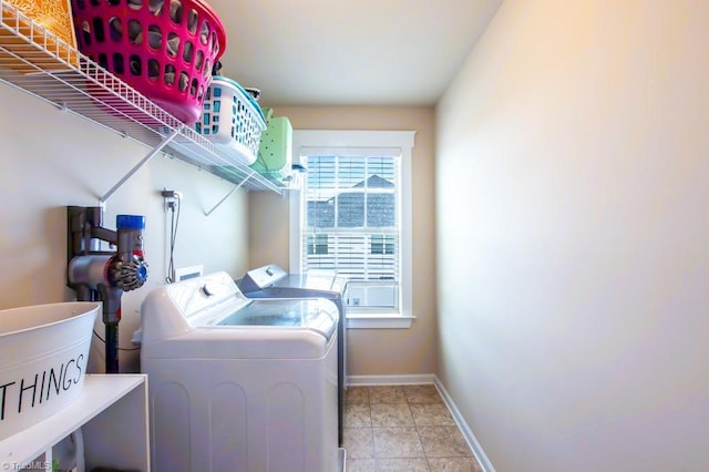 washroom featuring light tile patterned floors, laundry area, washing machine and dryer, and baseboards