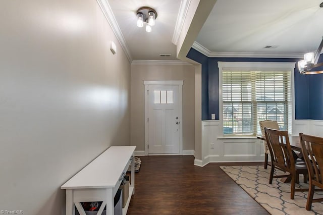 foyer with a decorative wall, dark wood-style flooring, visible vents, wainscoting, and crown molding