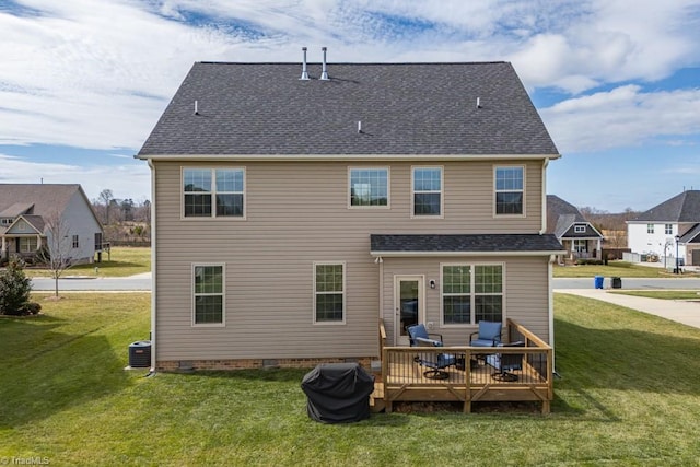 rear view of property featuring a wooden deck, roof with shingles, central AC, and a yard