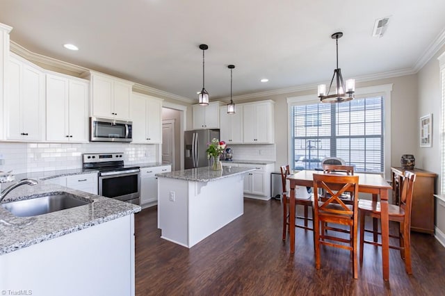 kitchen featuring crown molding, visible vents, stainless steel appliances, and a sink