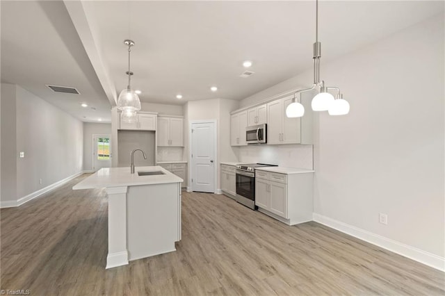 5421 High Valley Ln, Winston-Salem, NC 27104 - kitchen with stainless steel appliances, light wood-style flooring, recessed lighting, and a kitchen island with sink