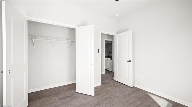 unfurnished bedroom with dark hardwood / wood-style floors and a closet