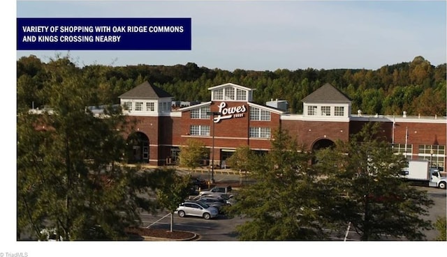 view of building exterior with a view of trees and uncovered parking