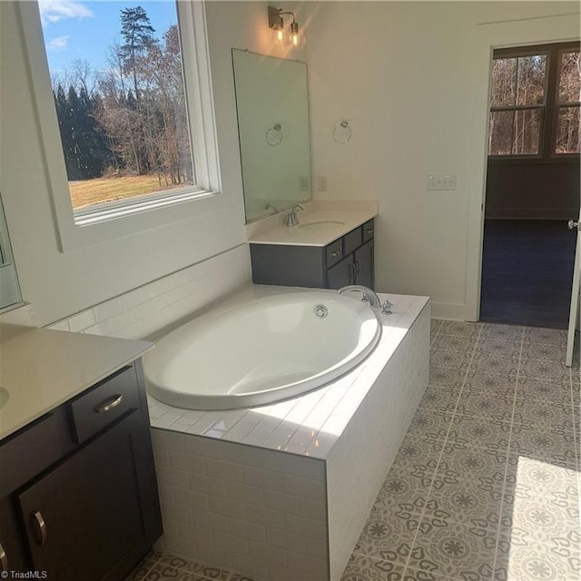 bathroom with tile patterned flooring, vanity, and a garden tub