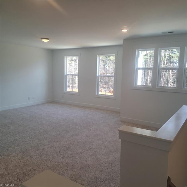 empty room featuring baseboards and carpet