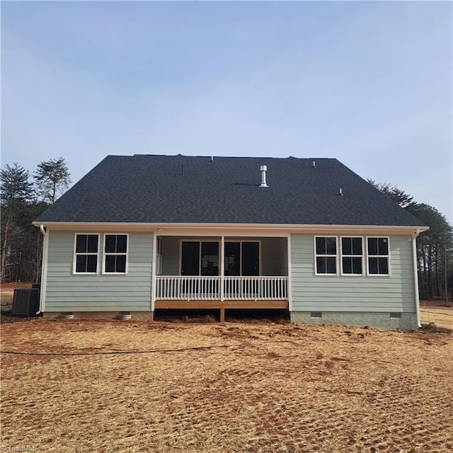 rear view of property featuring crawl space, cooling unit, and a shingled roof