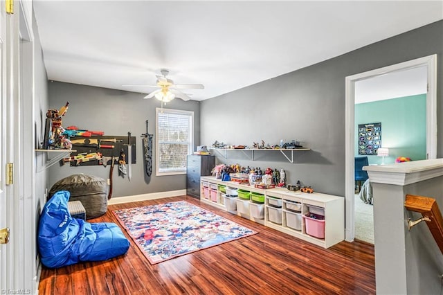 recreation room featuring dark hardwood / wood-style floors and ceiling fan