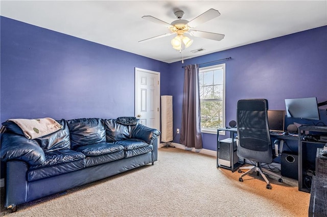 carpeted home office featuring ceiling fan