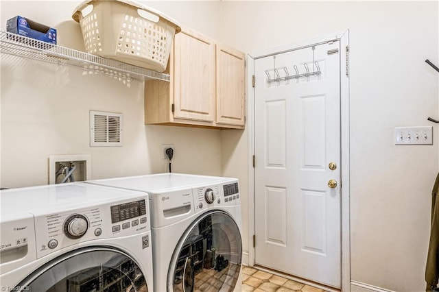 clothes washing area with cabinets and washer and clothes dryer