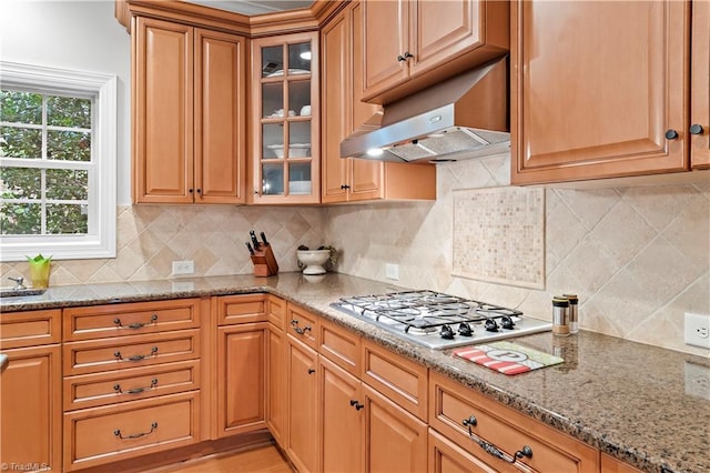 kitchen featuring light stone counters, stainless steel gas stovetop, and tasteful backsplash