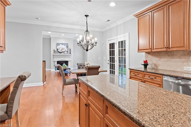 kitchen featuring tasteful backsplash, dishwasher, ornamental molding, light hardwood / wood-style floors, and light stone countertops