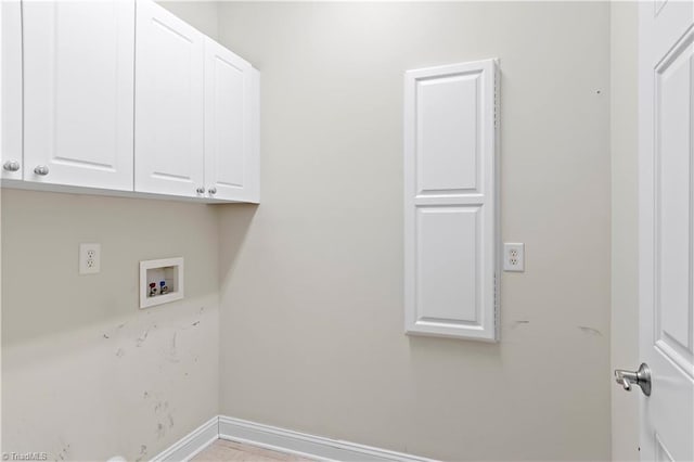 washroom featuring hookup for a washing machine and cabinets