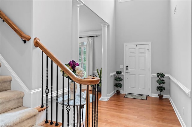 foyer entrance featuring decorative columns and light wood-type flooring