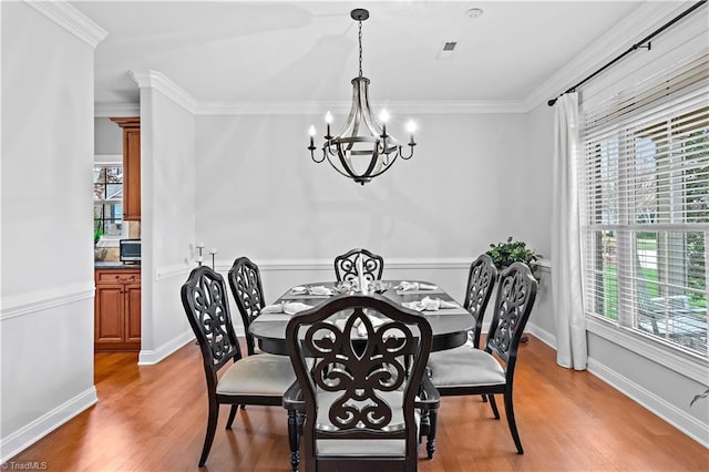 dining room featuring hardwood / wood-style flooring, ornamental molding, and plenty of natural light